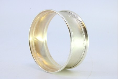 Argola de guardanapo em prata foscada e com frisos na envolvência.